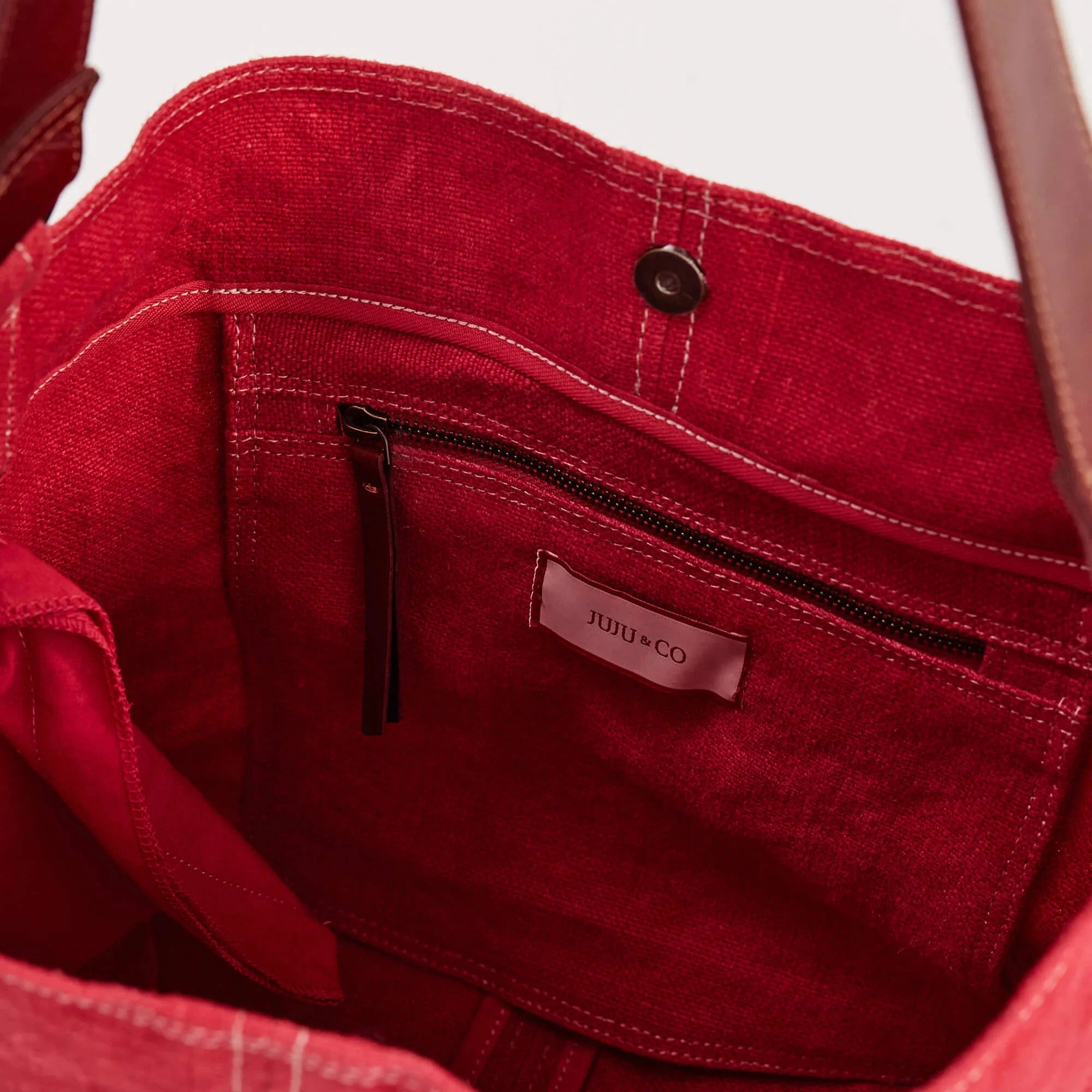 Red handbag with a visible brand label on a white background