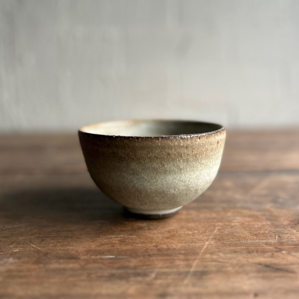Ceramic bowl on a wooden surface with a neutral background