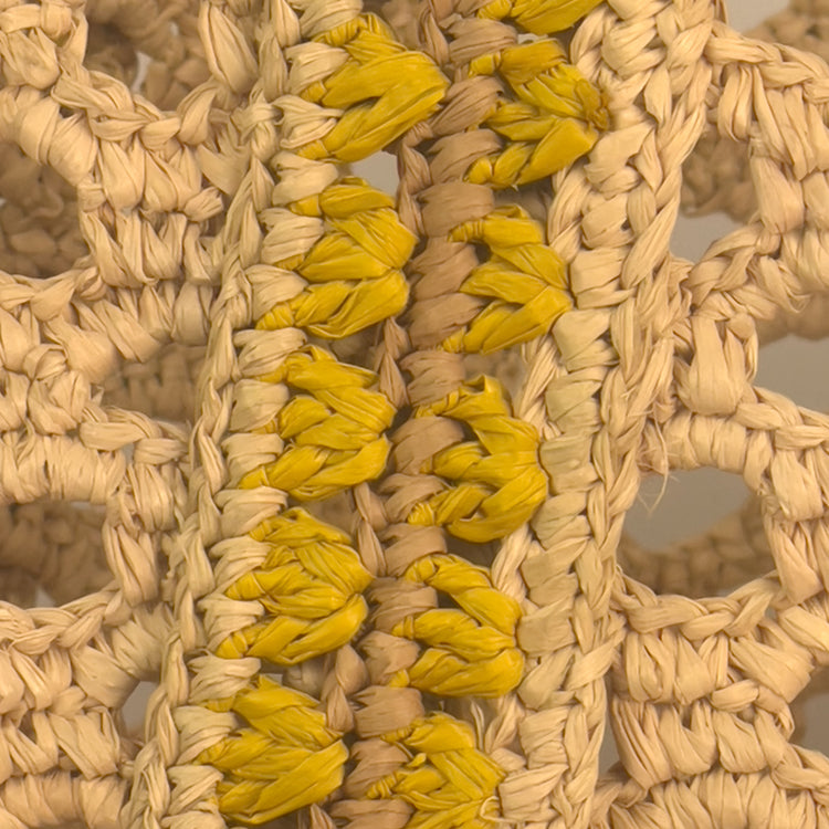 Close-up of a woven straw bag with yellow accents