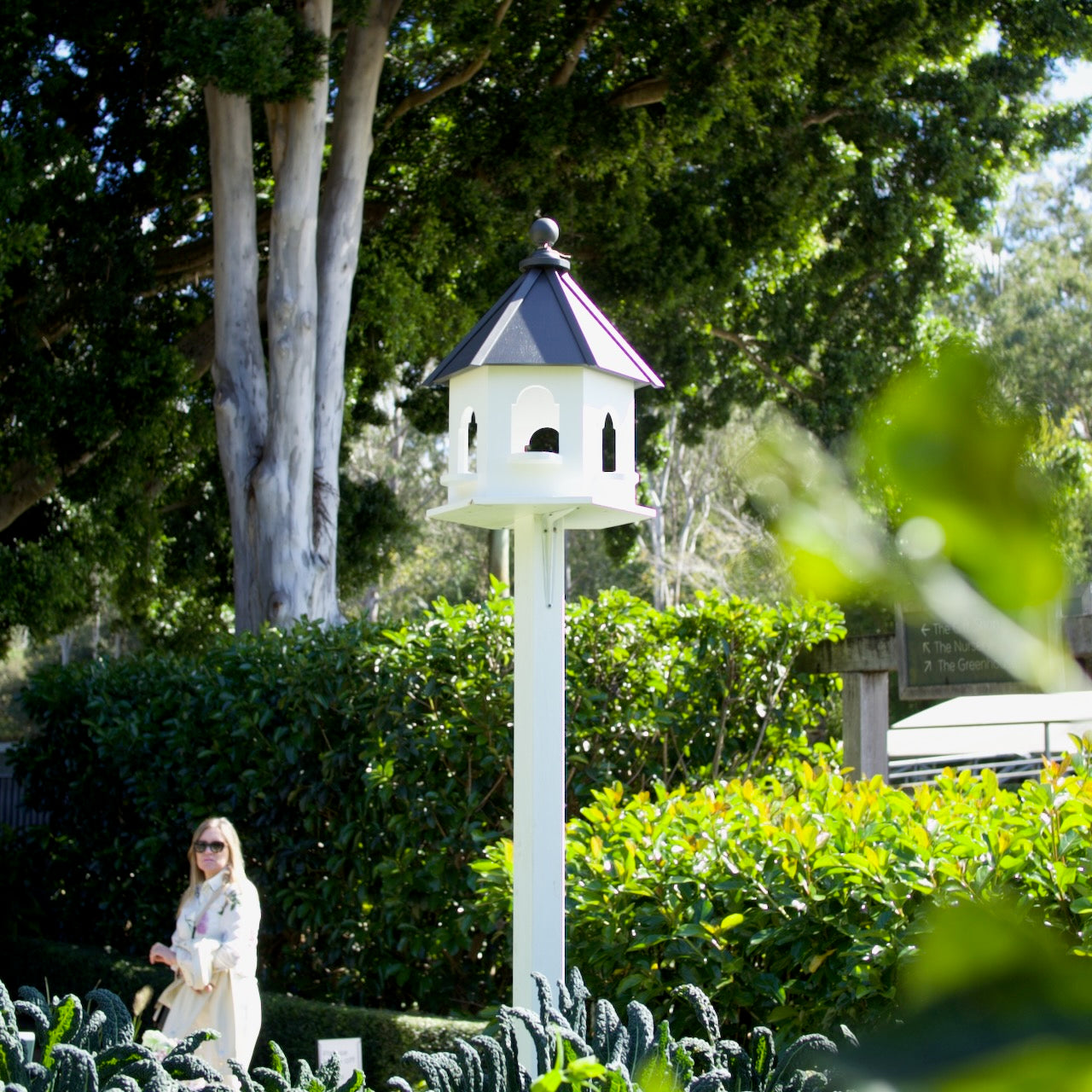 Elegant handmade white decorative dove cote in a lush Brisbane garden, mounted on a post as a timeless landscape feature.