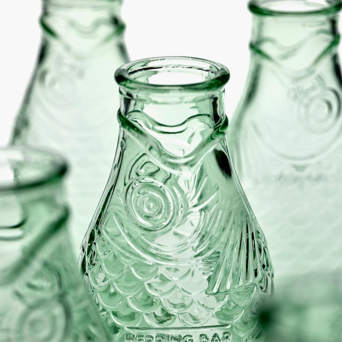 Close-up of green glass bottles with intricate patterns