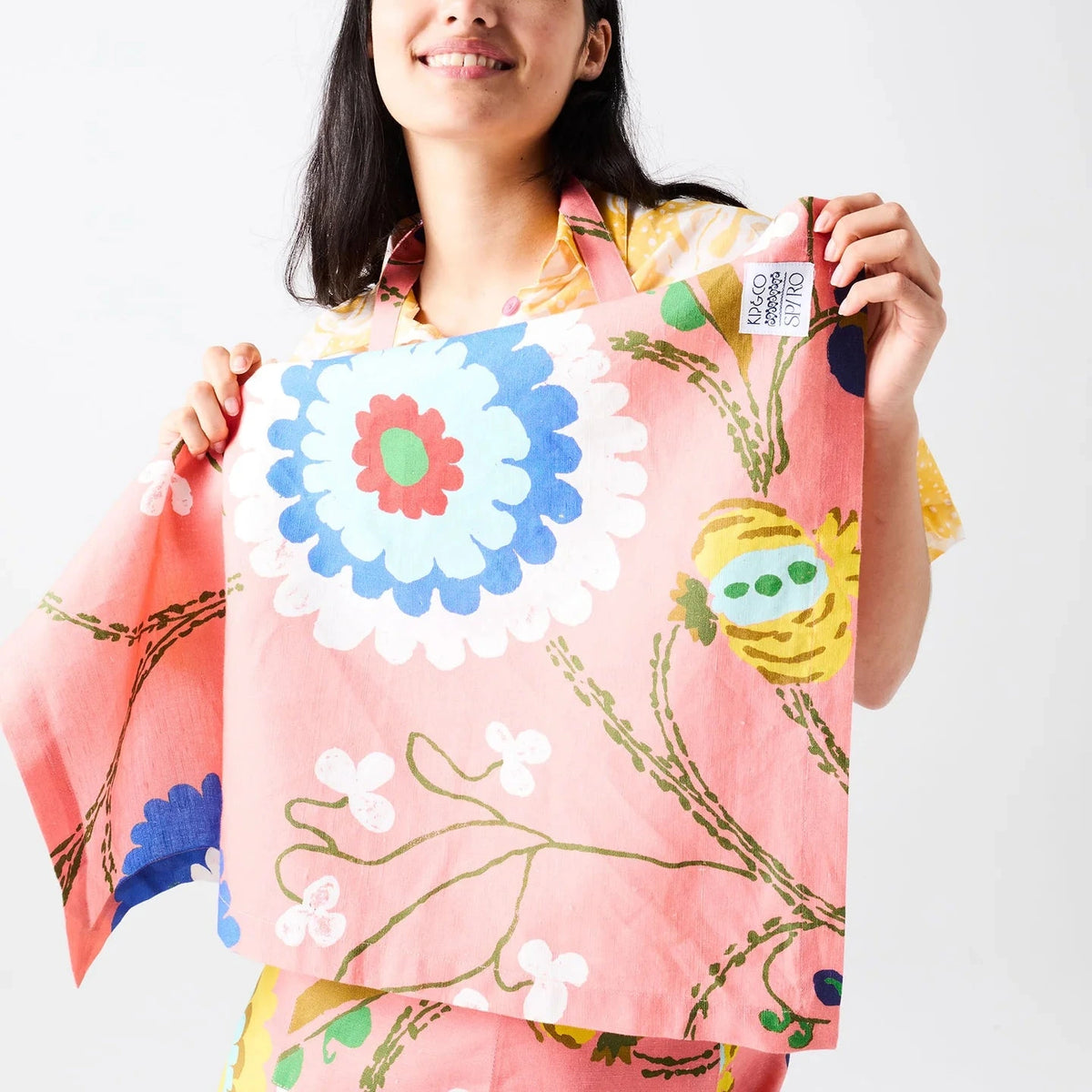Kip & Co x Anna Spiro Isabelle Sunset Tea Towel featuring oversized blue, aqua, white and yellow florals on a coral pink background.