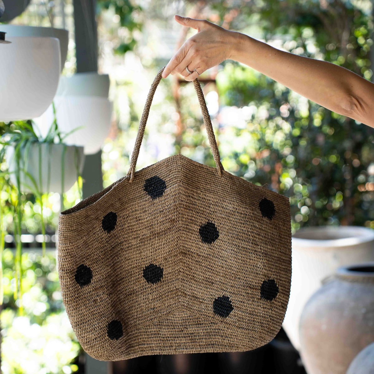 Made in Mada Gemma XXL Dots Bag in handwoven raffia with oversized black polka dots and long woven shoulder handles.
