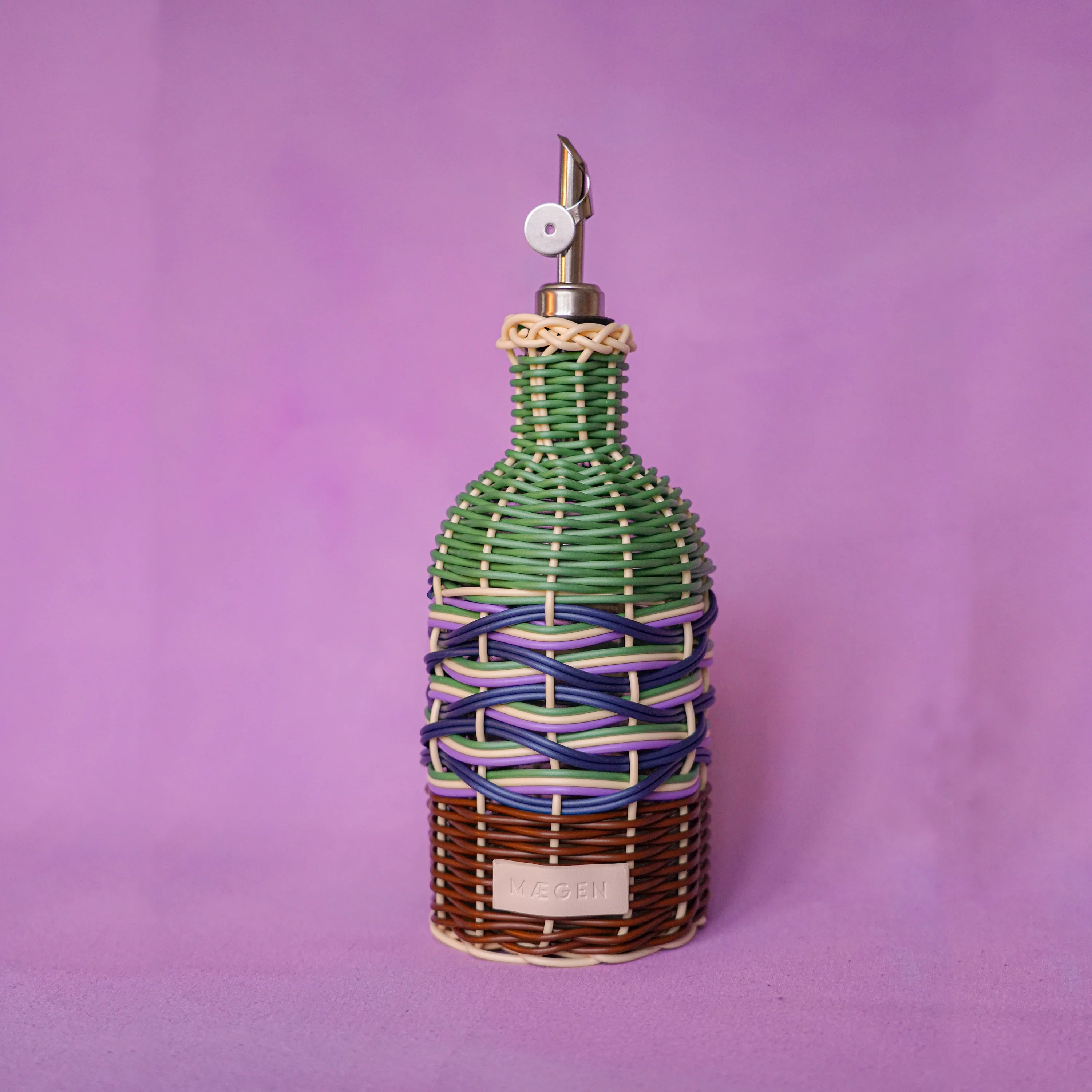 Maegen hand-woven oil pourer in green brown with multicolour accents, faux rattan texture and stainless steel spout