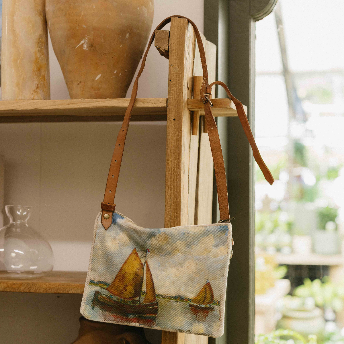 Swarm Ocean Landscape Cross Body Bag with painterly sailing boat design, aged leather strap and magnetic closure.