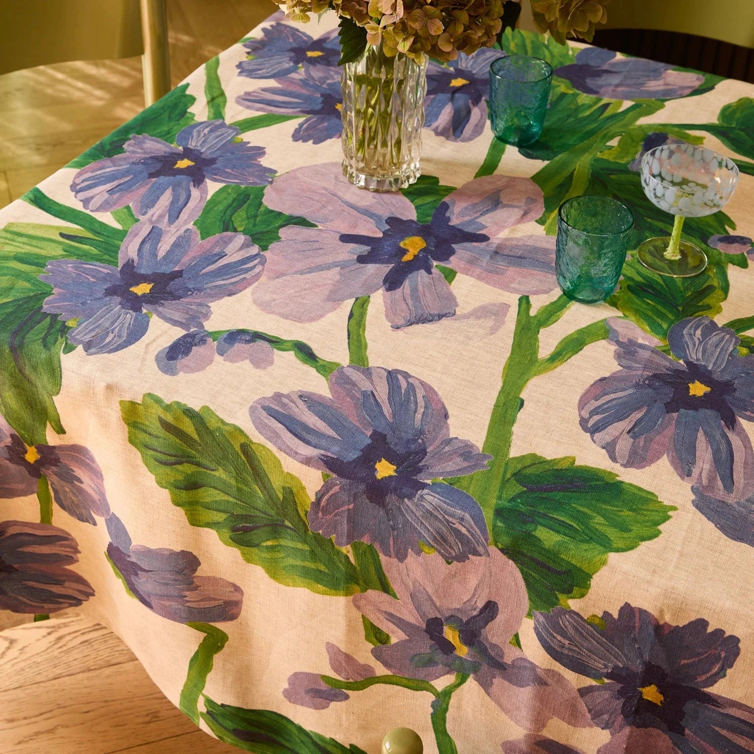 Bonnie and Neil Lilas Linen Tablecloth with soft lilac-blue florals and green foliage on oat linen.