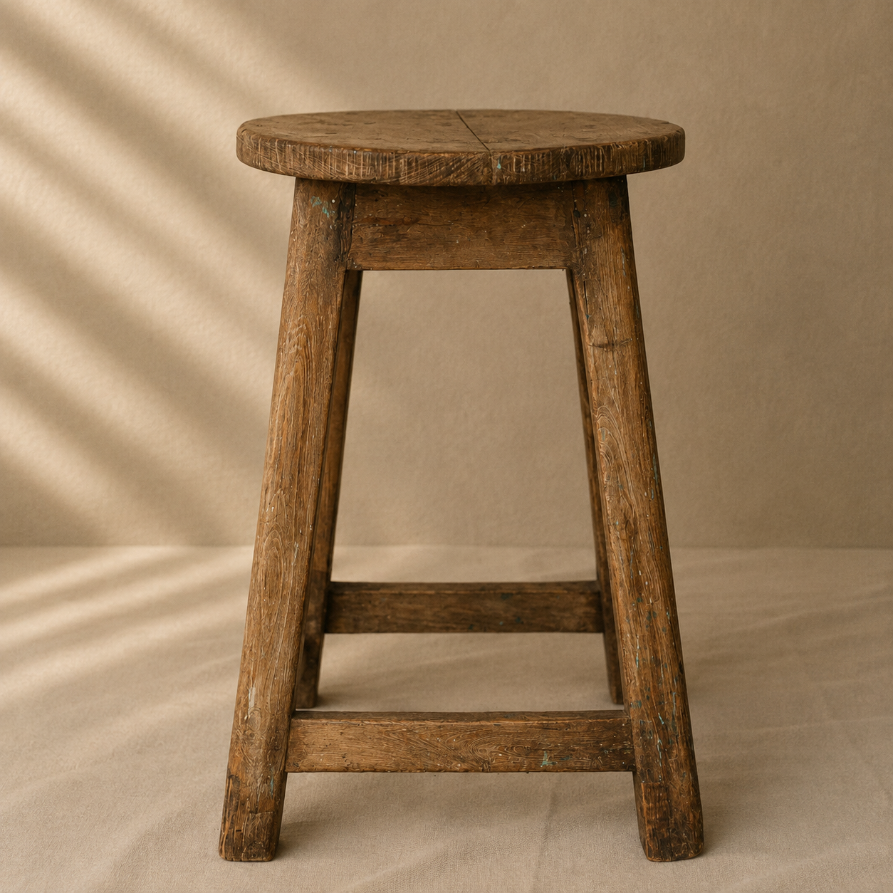 One-of-a-kind vintage Indian wooden stool with round seat, splayed legs and beautifully aged timber, exclusive to Brookfield Gardens.