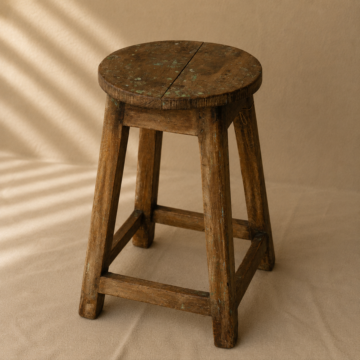 One-of-a-kind vintage Indian wooden stool with round seat, splayed legs and beautifully aged timber, exclusive to Brookfield Gardens.