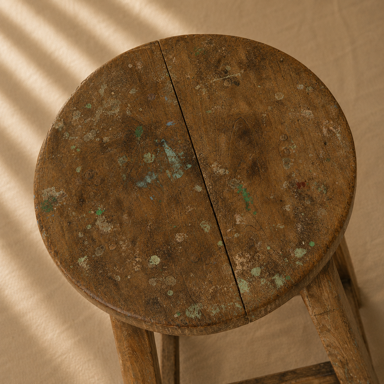 One-of-a-kind vintage Indian wooden stool with round seat, splayed legs and beautifully aged timber, exclusive to Brookfield Gardens.