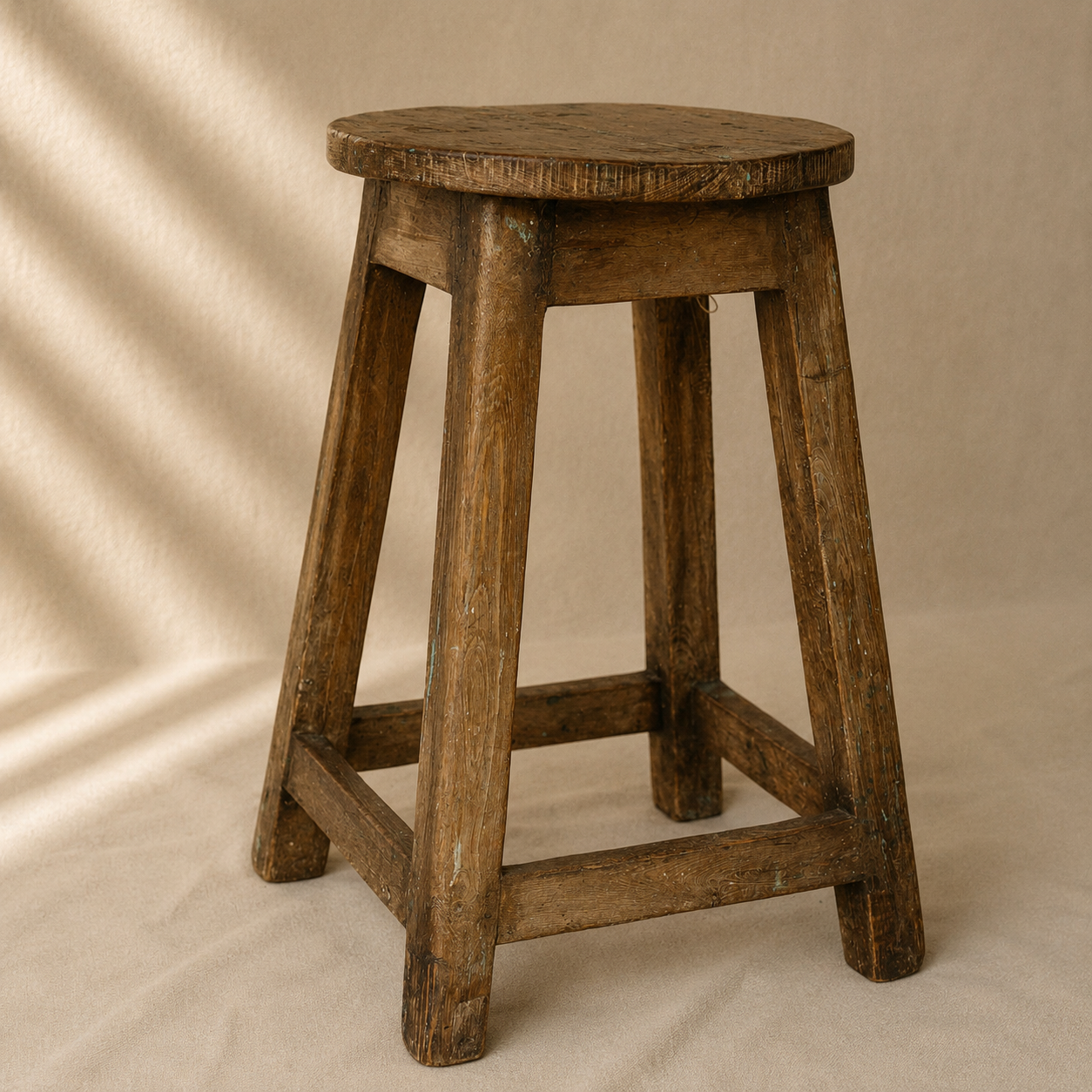 One-of-a-kind vintage Indian wooden stool with round seat, splayed legs and beautifully aged timber, exclusive to Brookfield Gardens.
