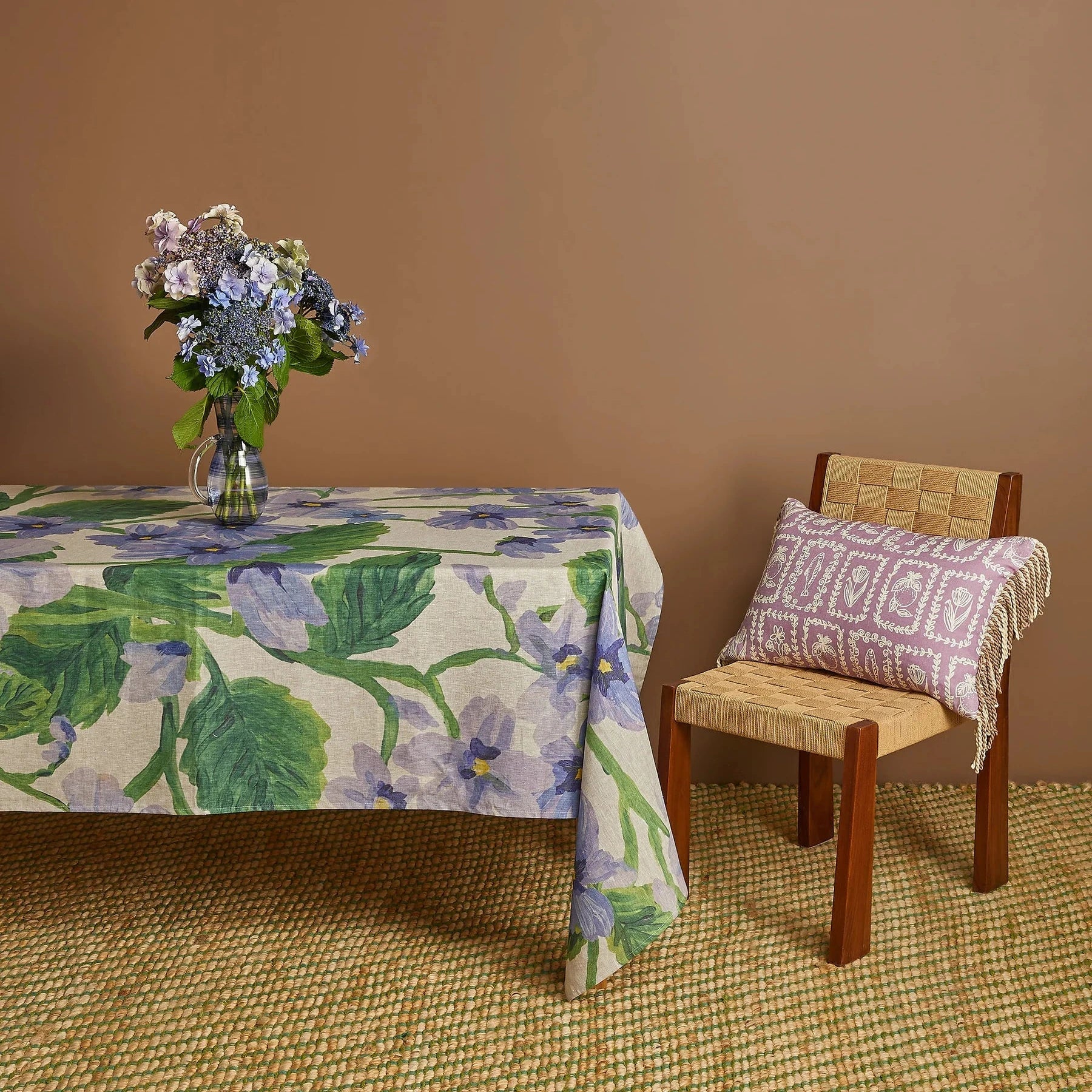 Bonnie and Neil Lilas Linen Tablecloth with soft lilac-blue florals and green foliage on oat linen.