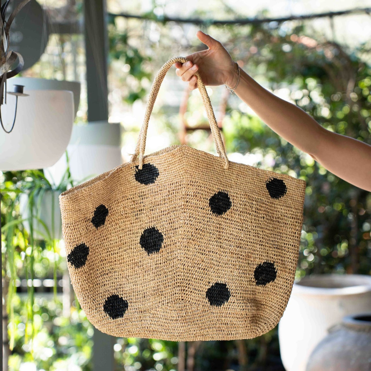 Made in Mada Gemma XXL Dots Bag in handwoven raffia with oversized black polka dots and long woven shoulder handles.
