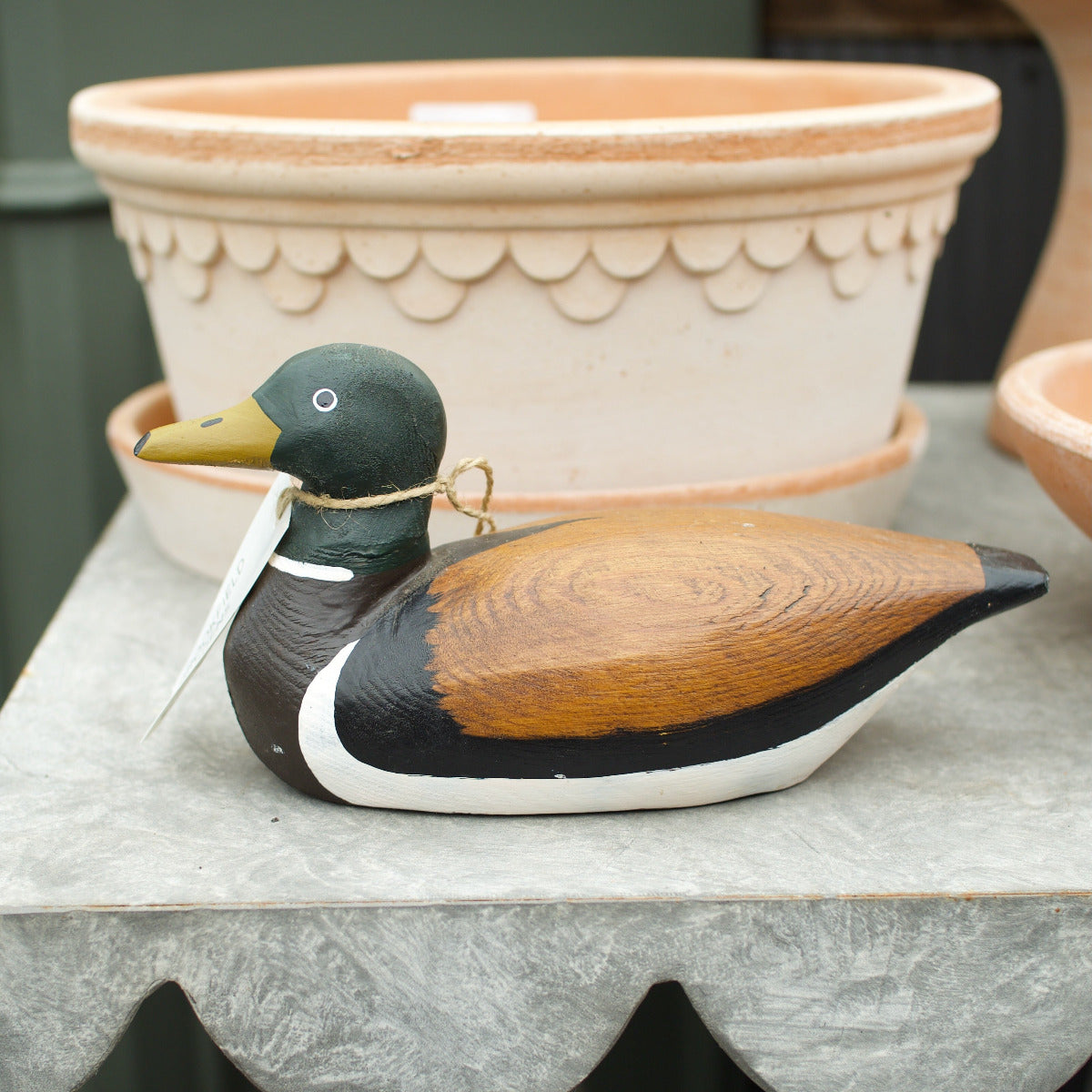 Hand-painted timber sitting duck with a natural wood wing and dark green head.