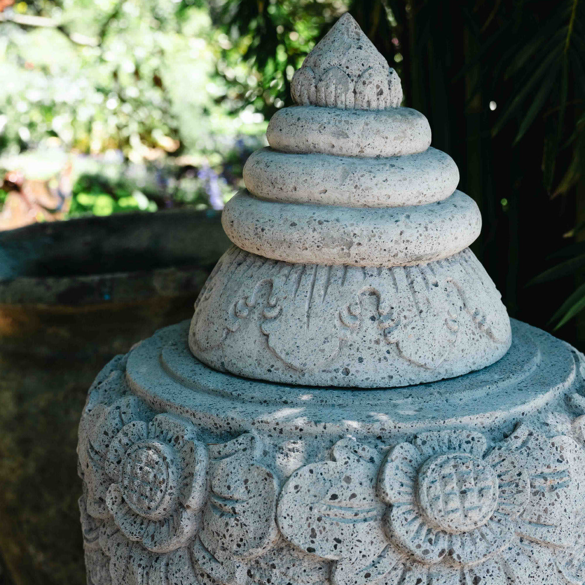 Decorative stone lantern with intricate carvings against a natural background