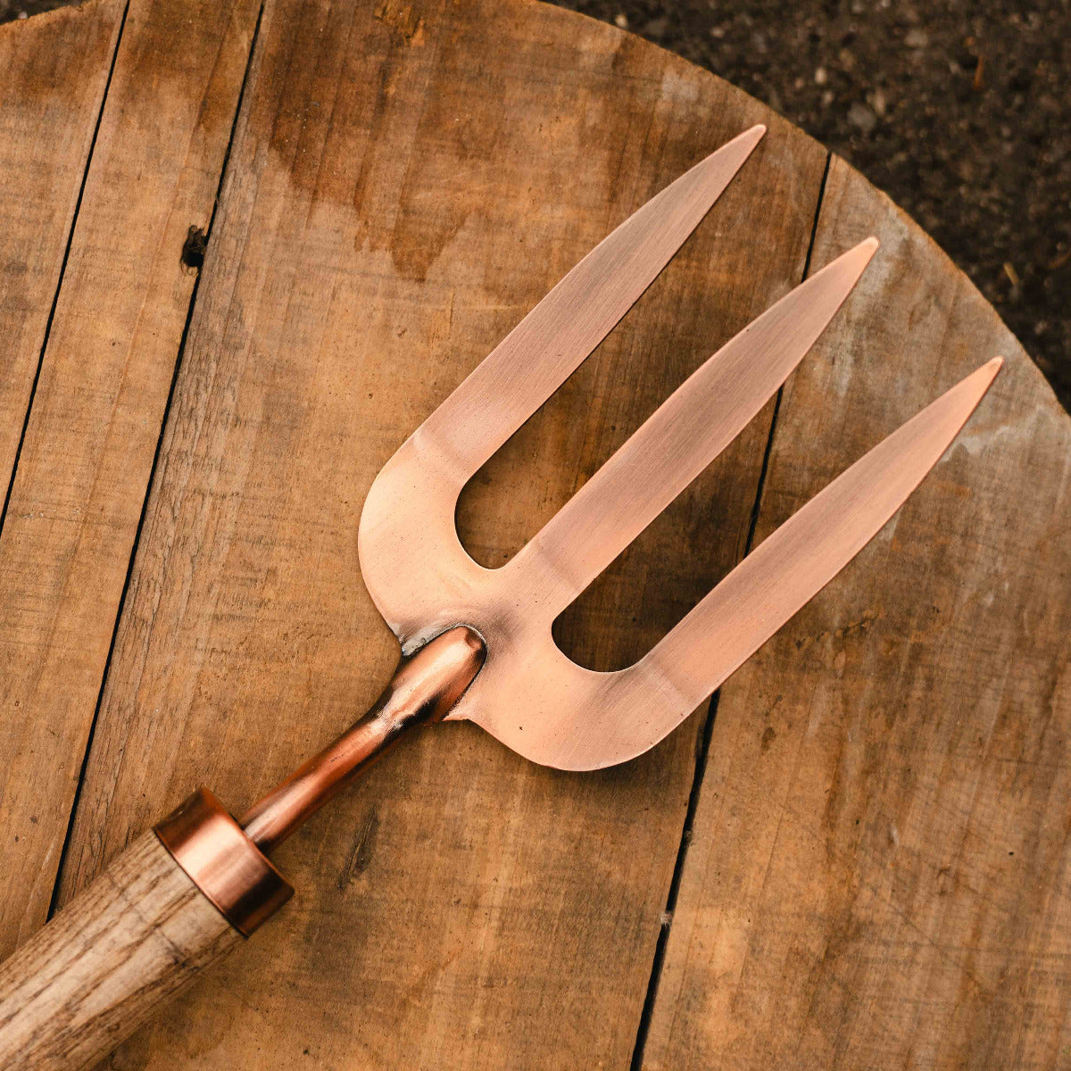 Copper meat fork on a wooden surface