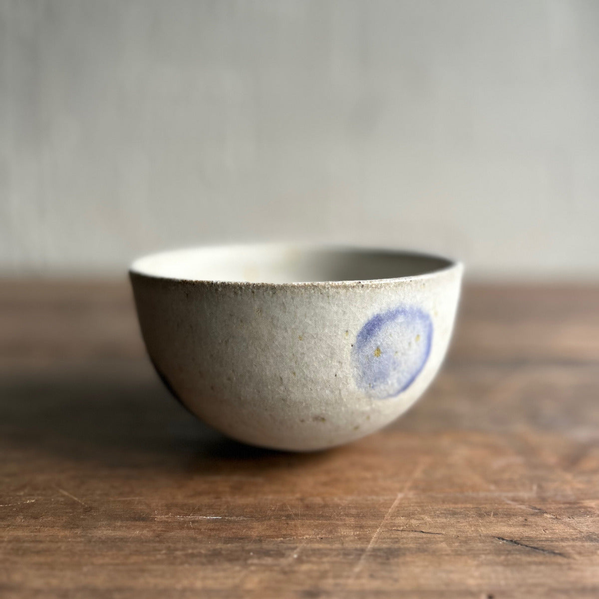Ceramic bowl with a blue circular design on a wooden surface