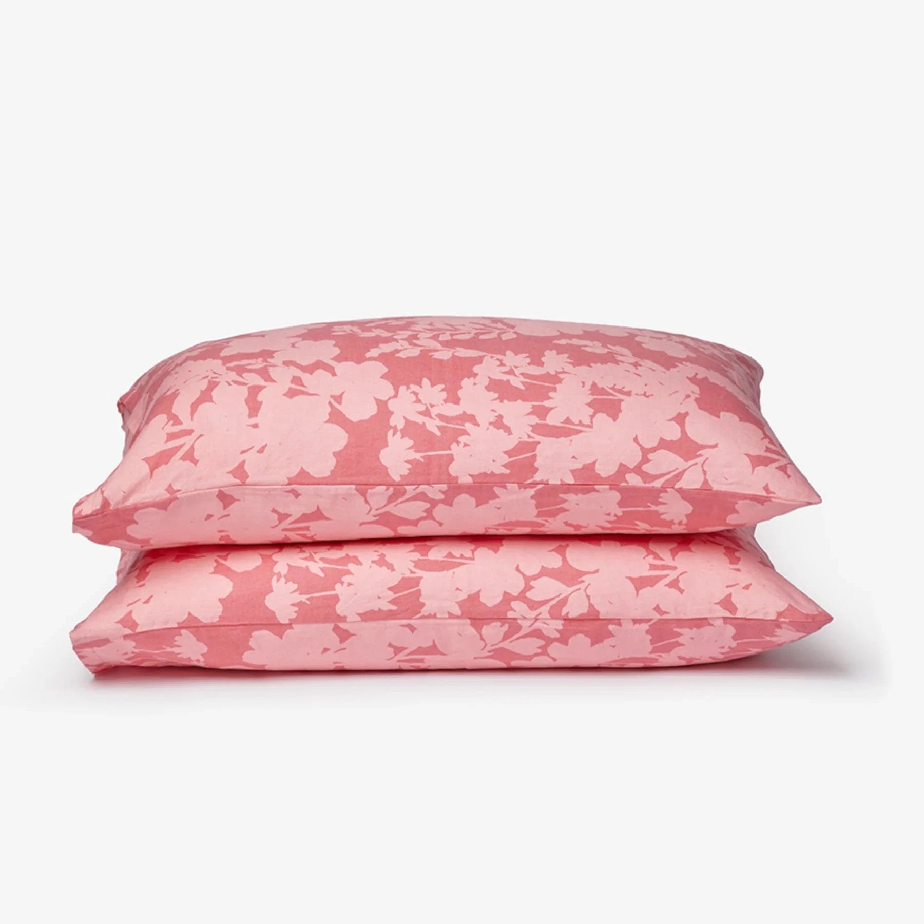 Two pink floral-patterned pillows on a white background