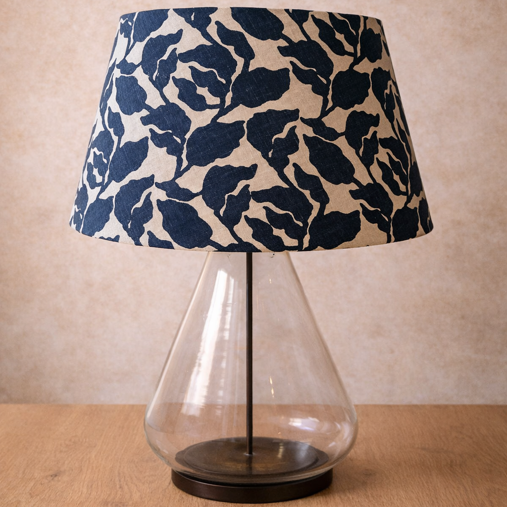 Table lamp with a blue floral patterned shade on a wooden surface.