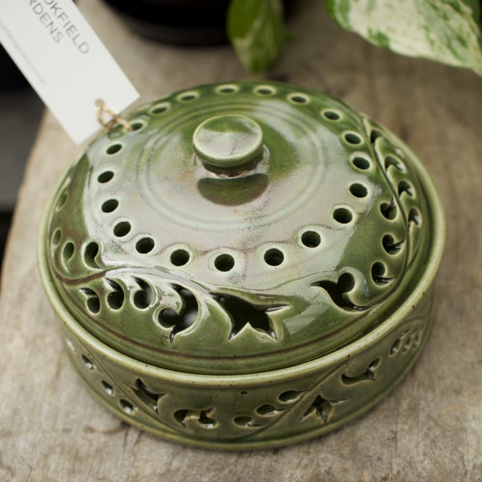 Green glazed ceramic mozzie coil holder with a decorative pierced lid for safely burning mosquito coils outdoors.
