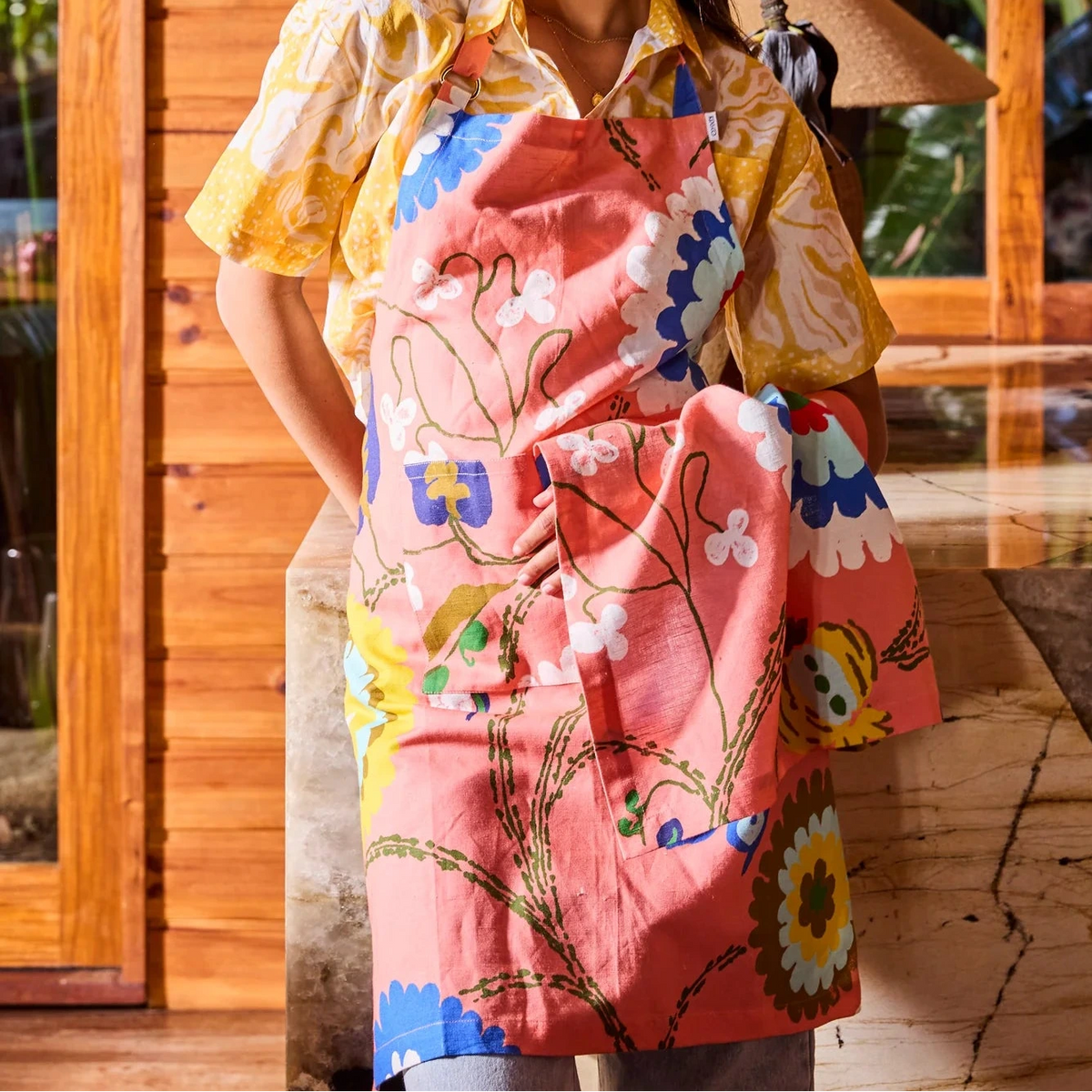 Kip & Co x Anna Spiro Isabelle Sunset Tea Towel featuring oversized blue, aqua, white and yellow florals on a coral pink background.