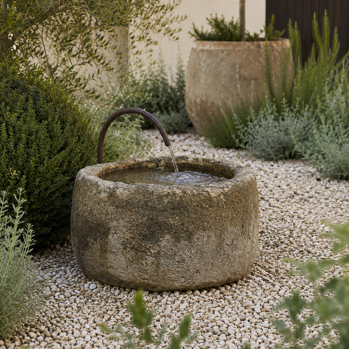 Stone water bowl with flowing water in a garden setting
