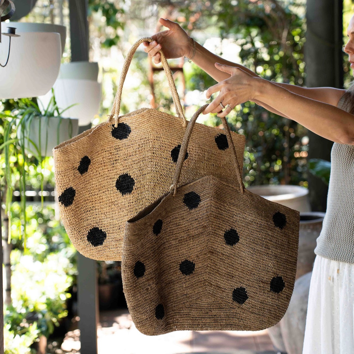 Made in Mada Gemma XXL Dots Bag in handwoven raffia with oversized black polka dots and long woven shoulder handles.