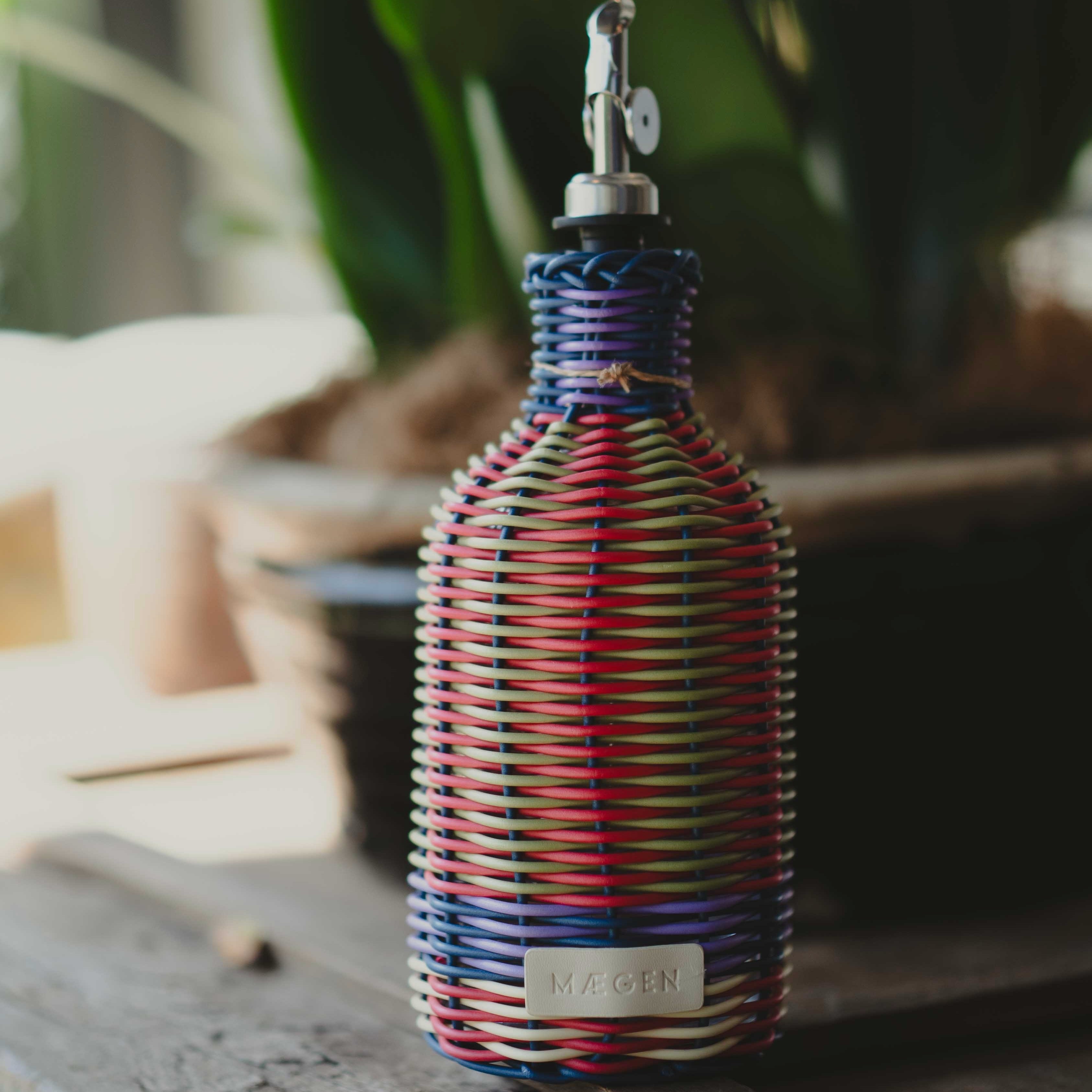 Colorful woven bottle with a label on a wooden surface