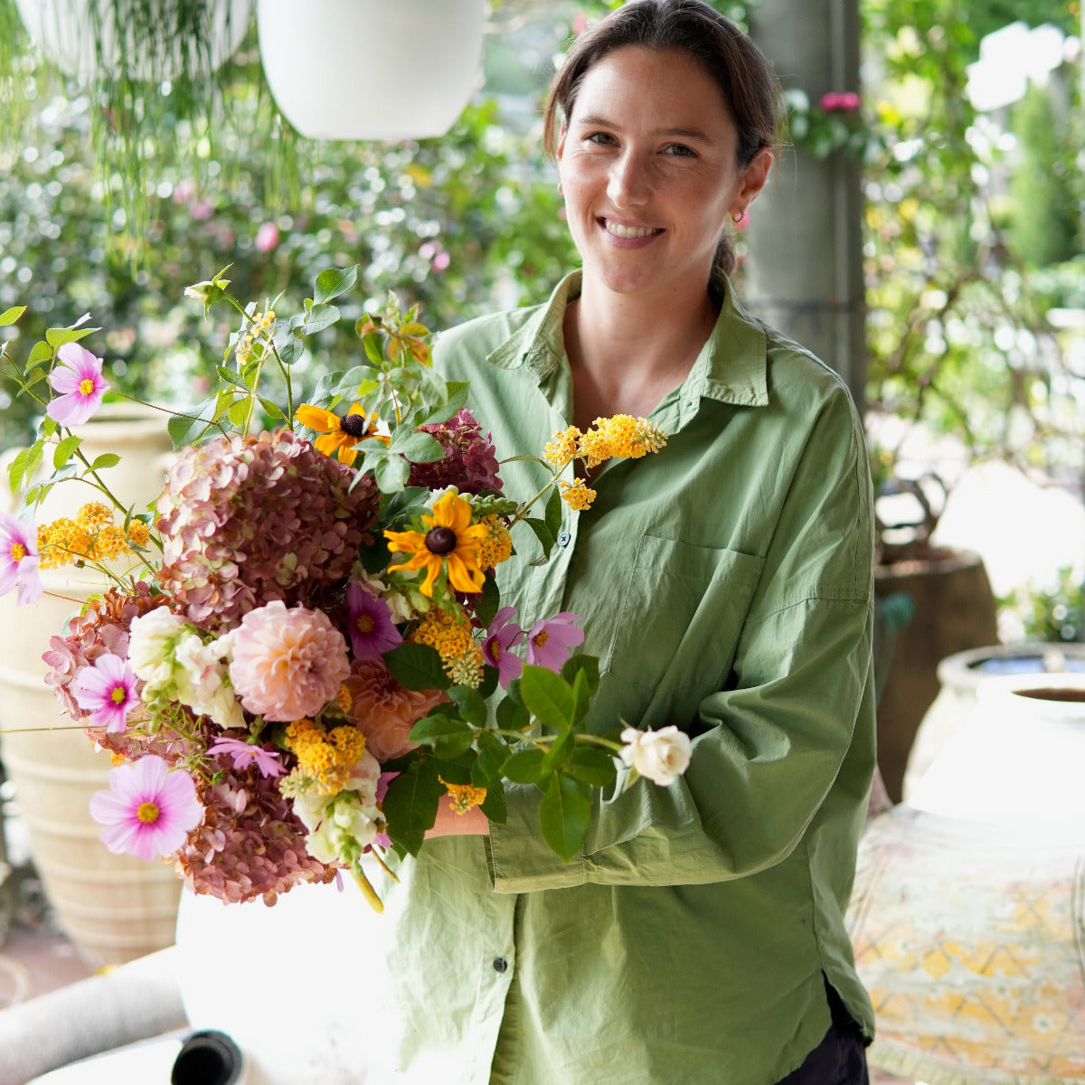 Woman holding a bouquet of flowers in an outdoor setting