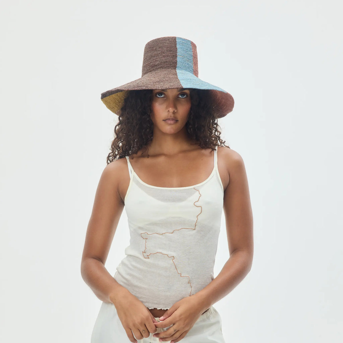 Tanora Rahel Sun handwoven raffia hat with terracotta sunburst design, natural earthy tones and wide wired brim, available at Brookfield Gardens.