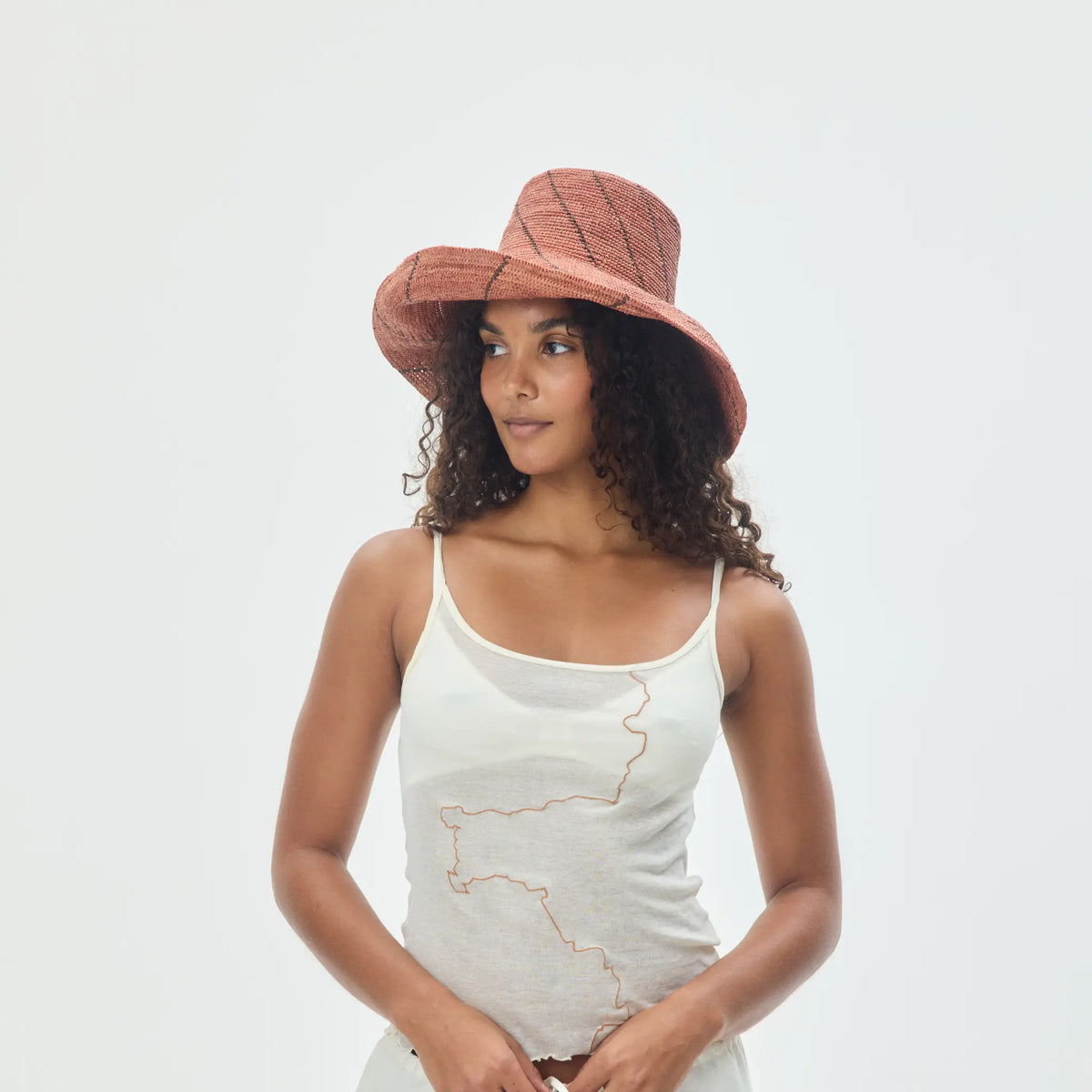 Tanora Rahel Horizon handwoven natural raffia hat featuring an earthy landscape-inspired pattern and wide wired brim, available at Brookfield Gardens.