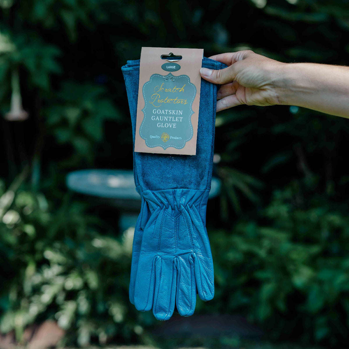 Blue glove held by a hand with a label against a green background