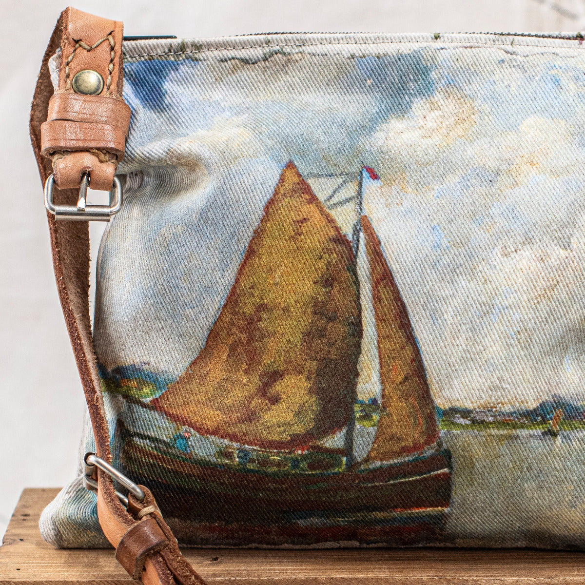 Swarm Ocean Landscape Cross Body Bag with painterly sailing boat design, aged leather strap and magnetic closure.