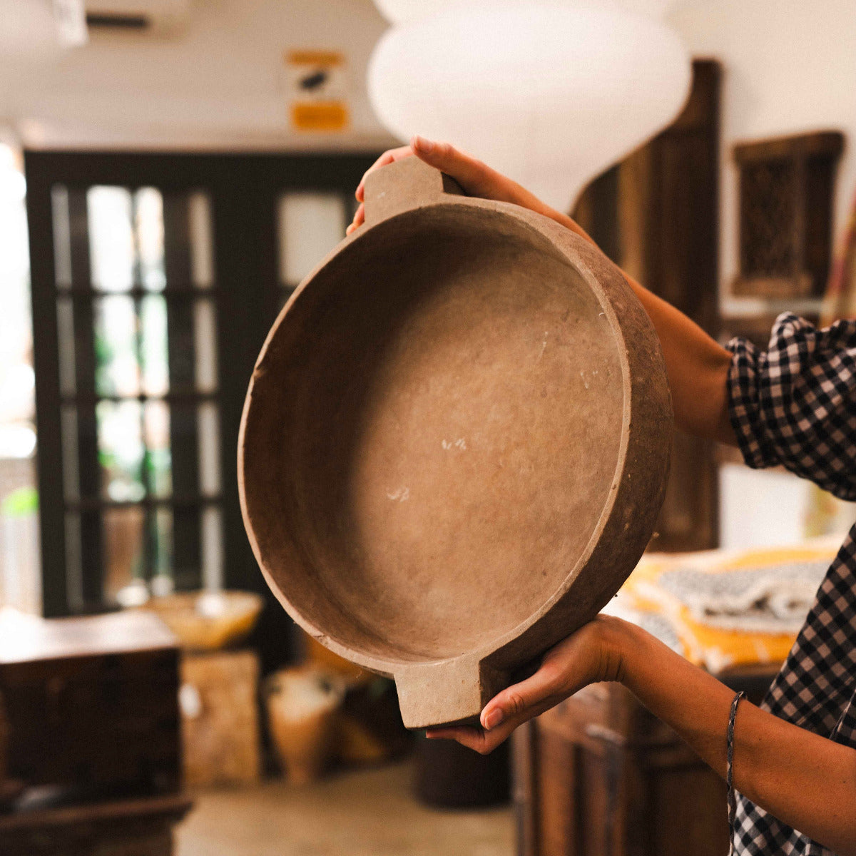 Terracotta low shallow bowl with wide rim and architectural side tabs, styled indoors.