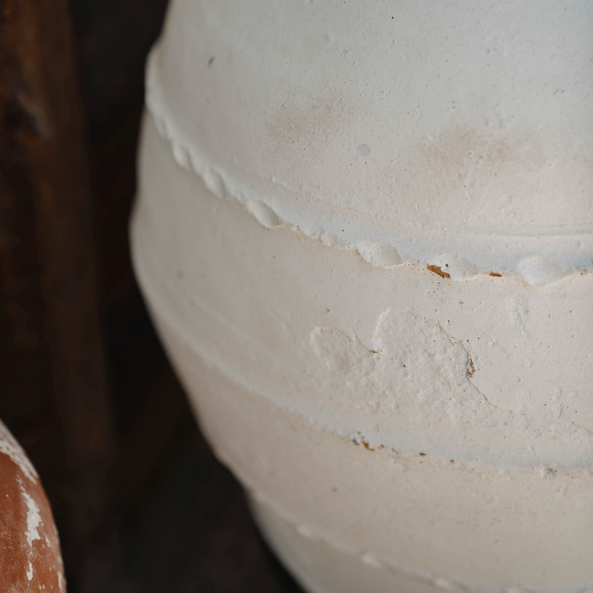 Close-up of a white ceramic pot with visible wear and tear.