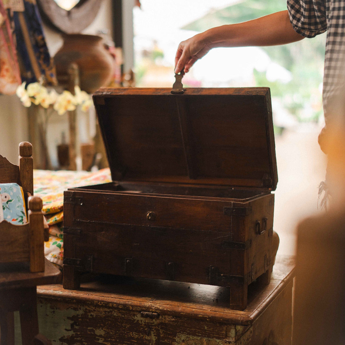 Person opening an old wooden chest with a blurred background