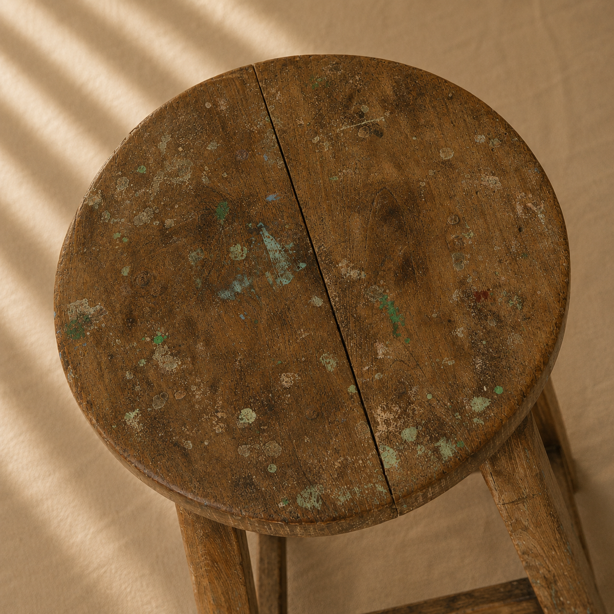 One-of-a-kind vintage Indian wooden stool with round seat, splayed legs and beautifully aged timber, exclusive to Brookfield Gardens.