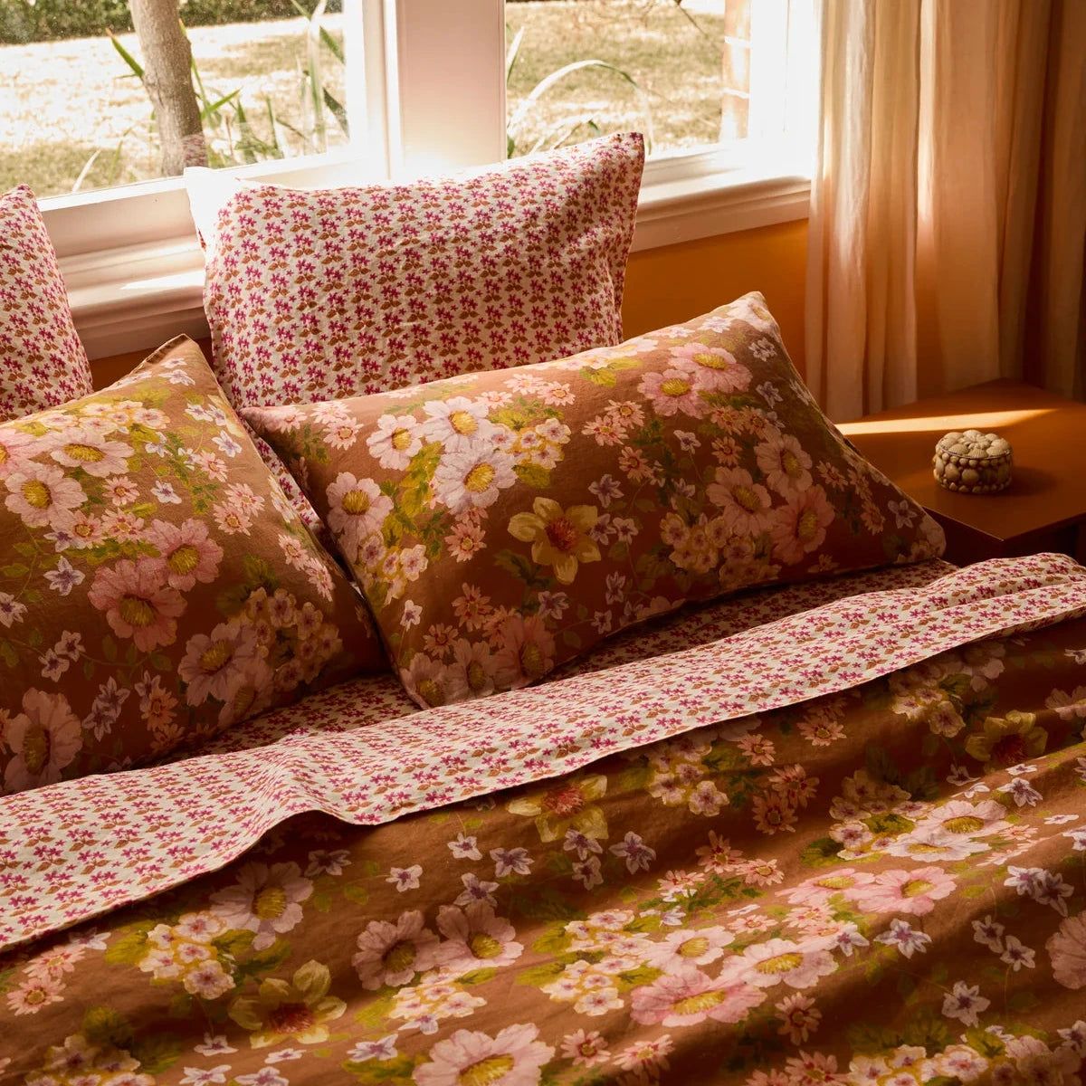 Bonnie & Neil Buttercup Rust standard linen pillowcases featuring colourful buttercup floral artwork on a warm rust background, set of two.