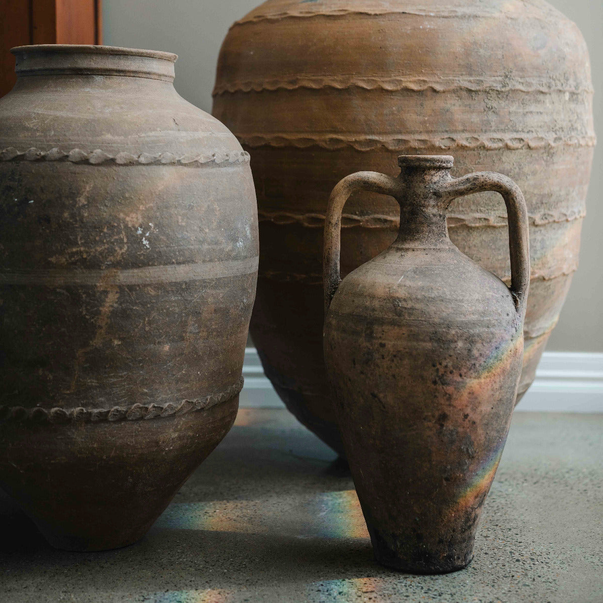 Hand painted Turkish amphora with twin handles and aged terracotta finish styled indoors