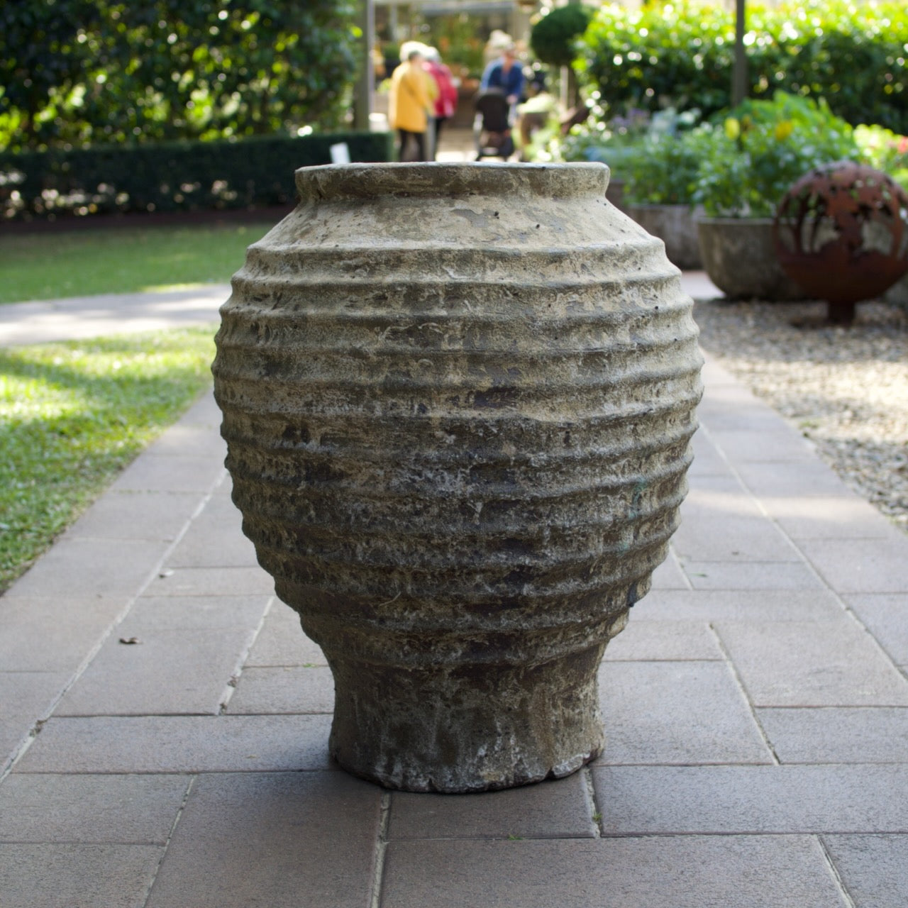 Rustica Bella Urn with a textured ribbed design and weathered antique finish, displayed as a Mediterranean-inspired feature planter at Brookfield Gardens, Brisbane.