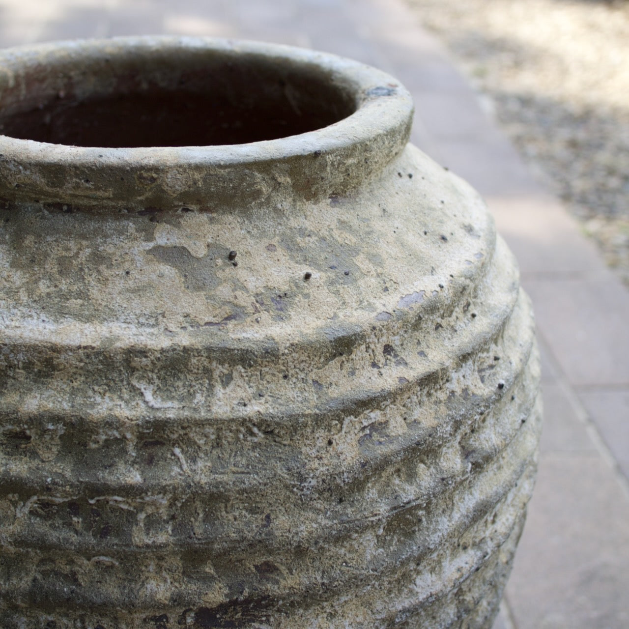 Rustica Bella Urn with a textured ribbed design and weathered antique finish, displayed as a Mediterranean-inspired feature planter at Brookfield Gardens, Brisbane.